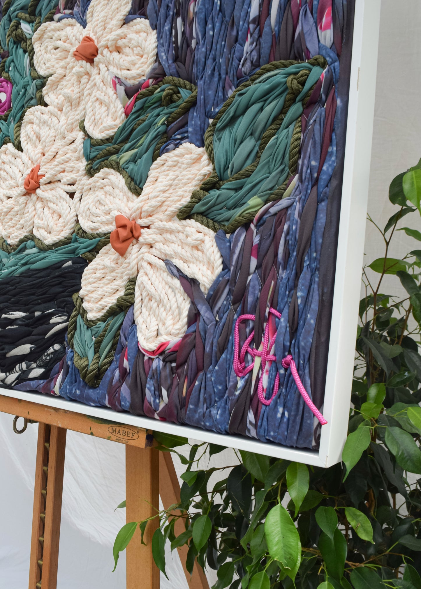 Close-up detail of textured floral vase embroidery, statement artwork