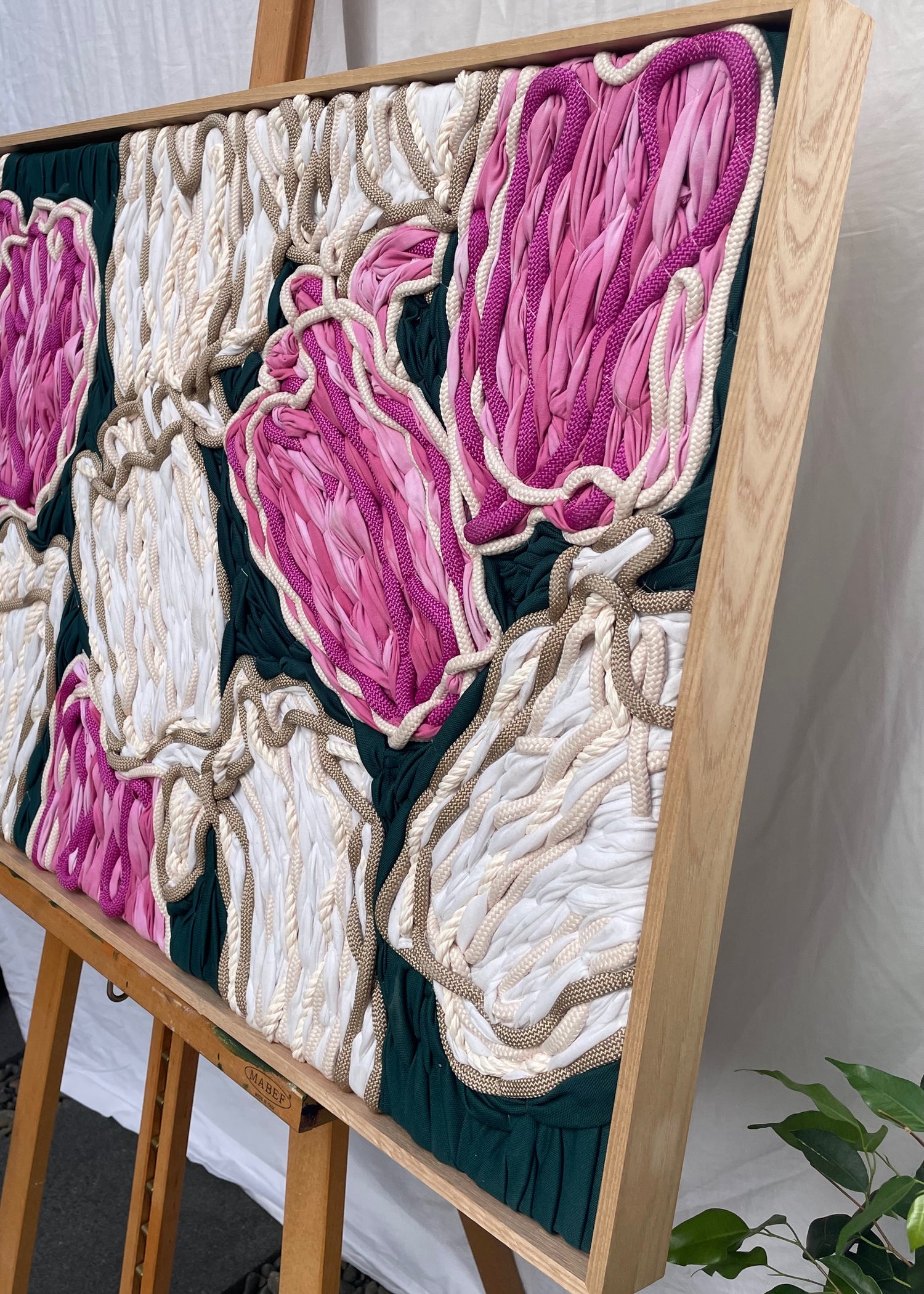 Close-up detail of hand stitched pink and cream tulips in framed tapestry