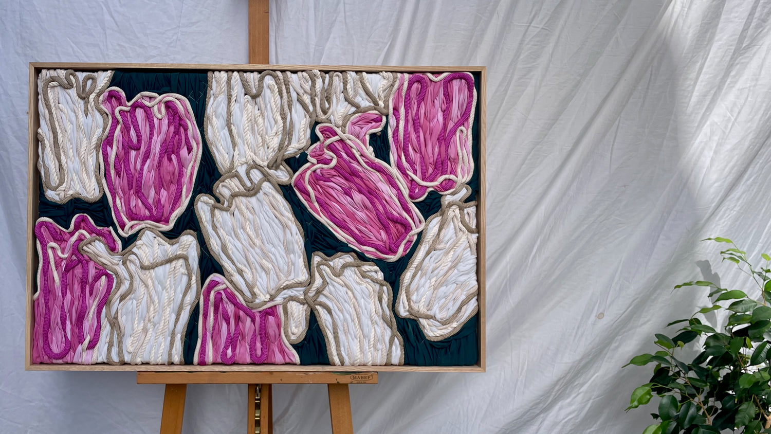 Framed floral embroidery tapestry featuring pink and cream tulips