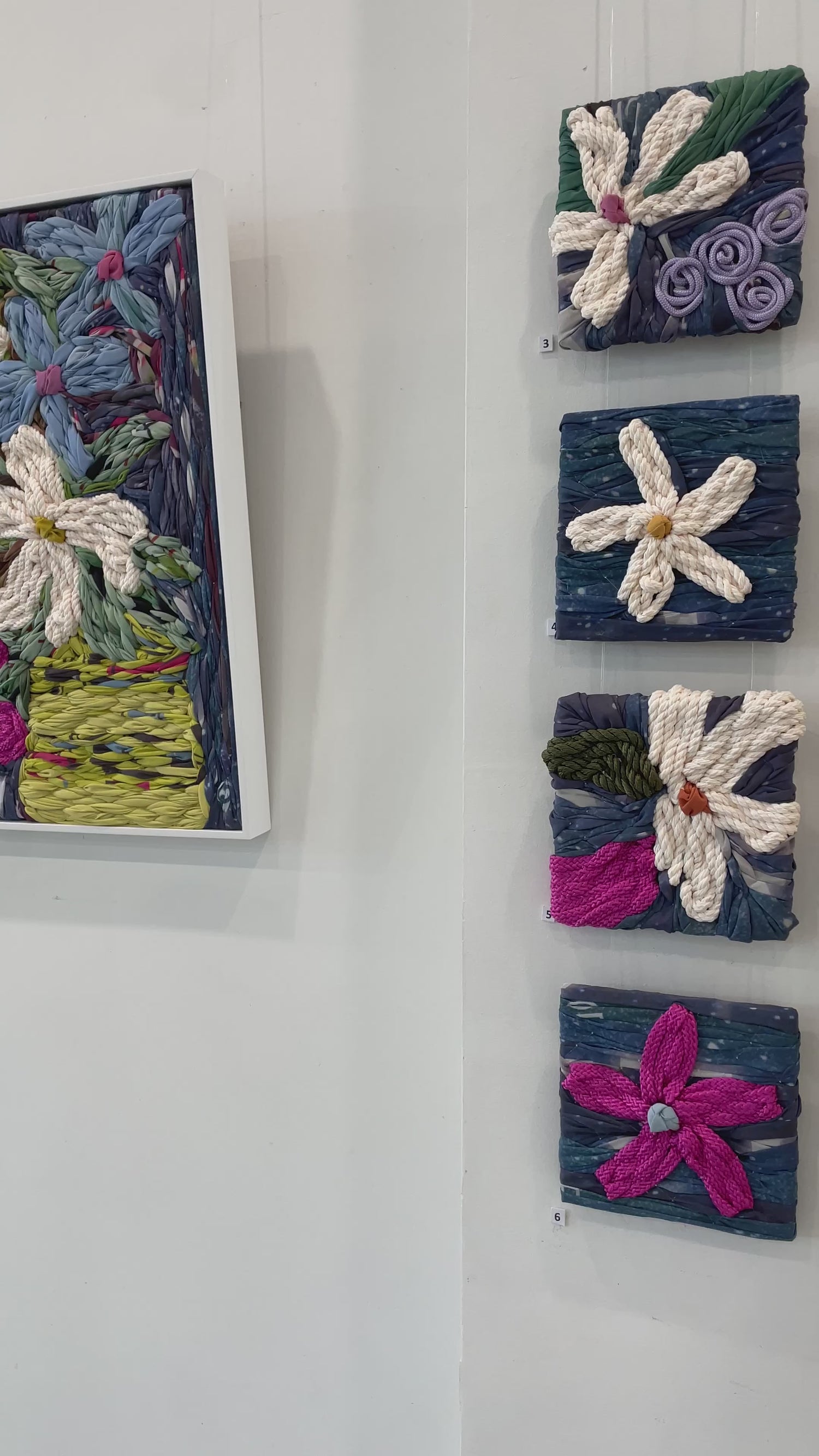 Beautiful floral tapestry art made from recycled materials, hanging in a gallery