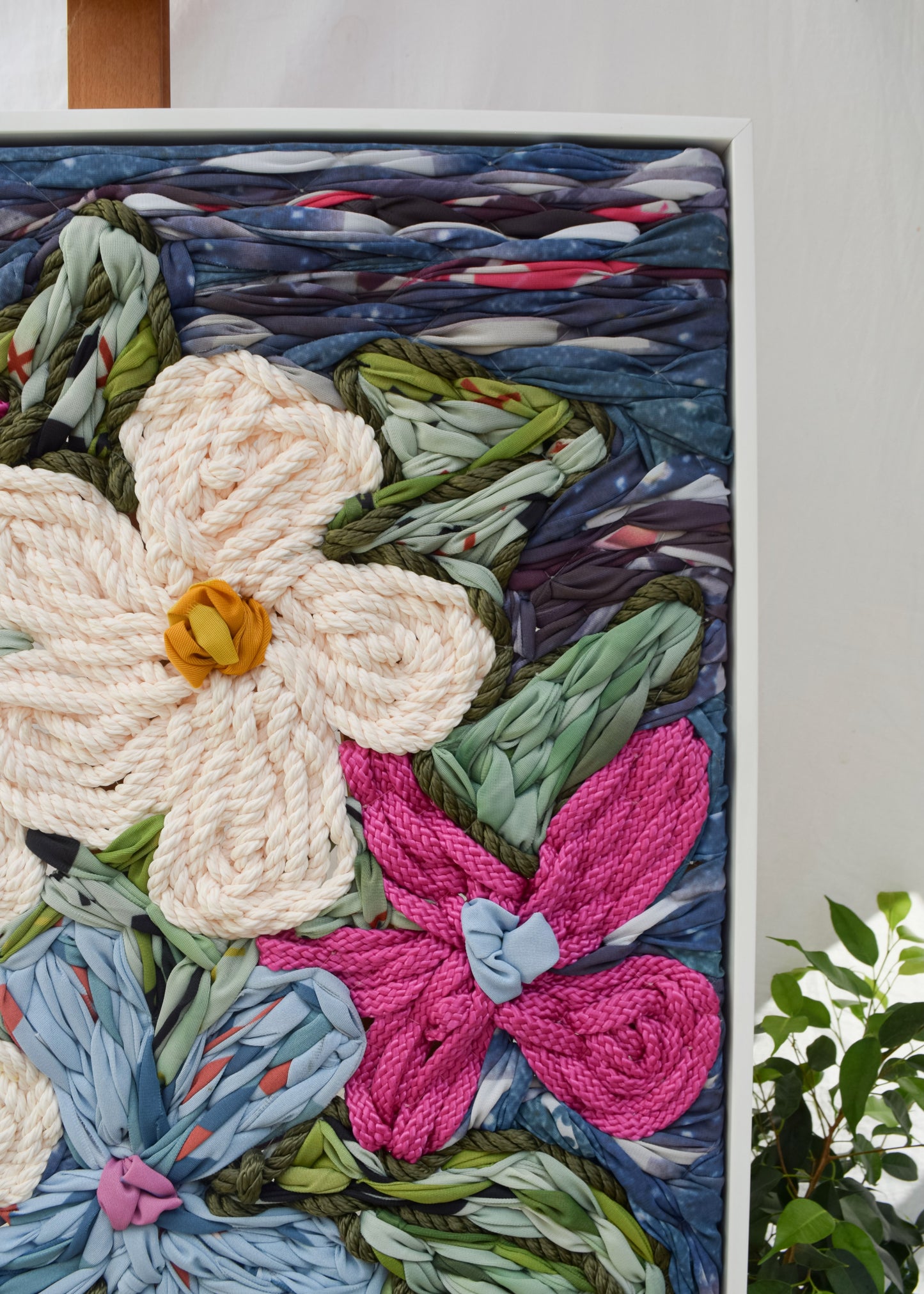 Close-up detail of textured floral vase embroidery, oversized artwork